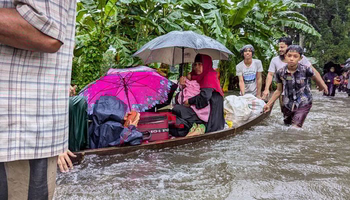 People wade through flood waters in Feni, Bangladesh on August 22, 2024. — AFP