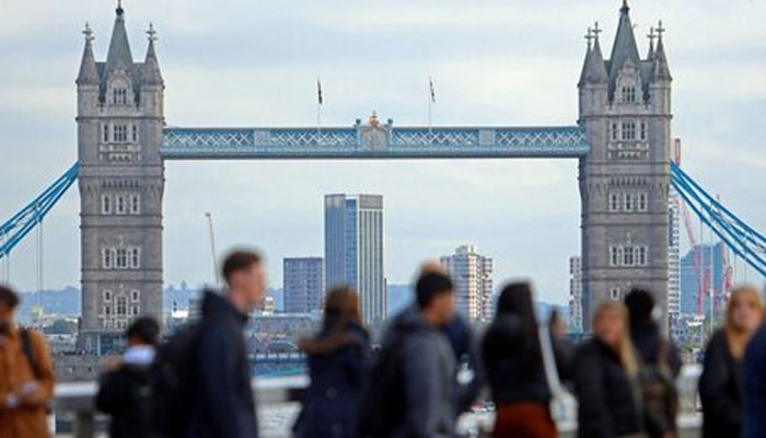 People walk over London Bridge looking at a view of Tower Bridge in the City of London financial district in London, Britain on October 25, 2023. — Reuters