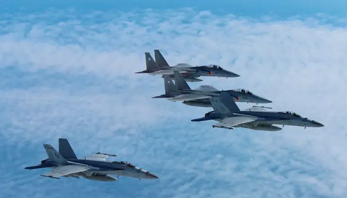 Japan’s Self-Defense Force’s F-15 fighter jets (top and 2nd from top) conduct an air exercise with US Navy F/A 18 Hornet aircrafts in the skies above the Sea of Japan.— Reuters