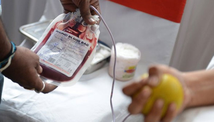A representational image showing a person holding a blood bag. — AFP/File