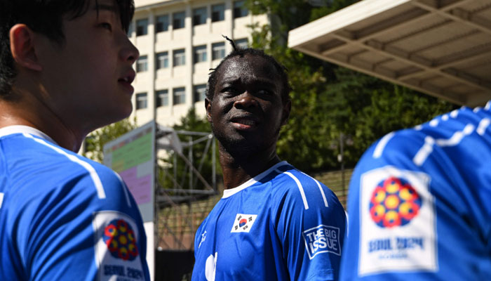 Cameroon refugee Fossi Wandji (C, #99) reacts with his South Korean teammates before the mens group stage 4x4 football match between South Korea and Switzerland at the 2024 Homeless World Cup in Seoul on September 24, 2024. — AFP