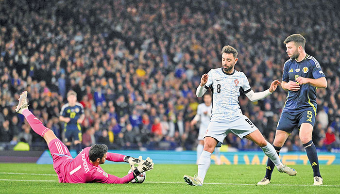 Scotland’s goalkeeper Craig Gordon (left) stops the ball shot by Portugal’s midfielder Bruno Fernandes during the UEFA Nations League, League A Group A1 match against Portugal at Hampden Park Stadium here on Oct 15, 2024. — AFP