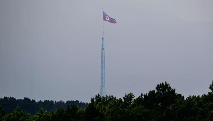 A North Korean flag seen from Paju in South Korea flutters over the village of Gijungdong in July 2024.  — AFP/File