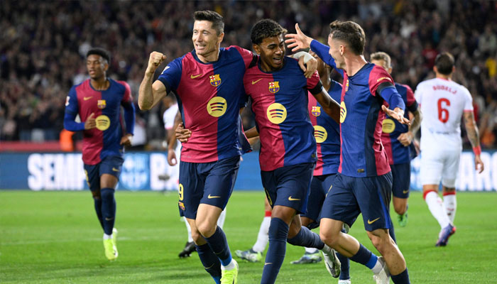 Barcelona´s Polish forward Robert Lewandowski (left) celebrates scoring the opening goal from the penalty spot during the Spanish league football match between FC Barcelona and Sevilla FC at the Estadi Olimpic Lluis Companys in Barcelona on October 20, 2024. — AFP