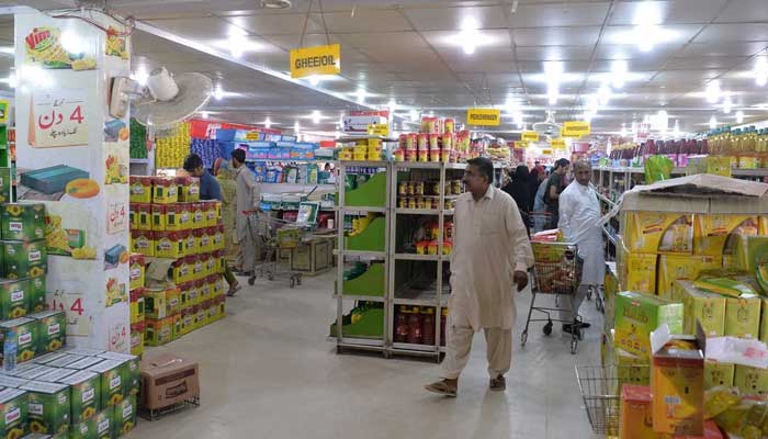 Customers buy food items at a utility store with government-controlled prices in Islamabad on May 16, 2018. — AFP