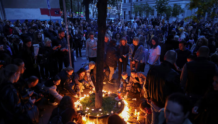 People gather for a candlelight vigil near the school in Serbia.—Reuters/file