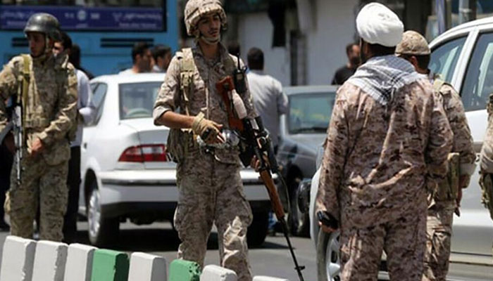 Iran´s security personnel standing on road. — AFP/File