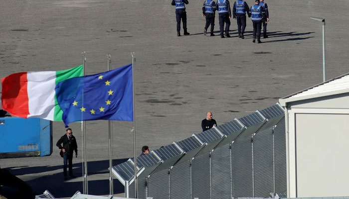 Police officers walk outside an Italian-run migrant detention camp in Albania on October 16th 2024. — AFP
