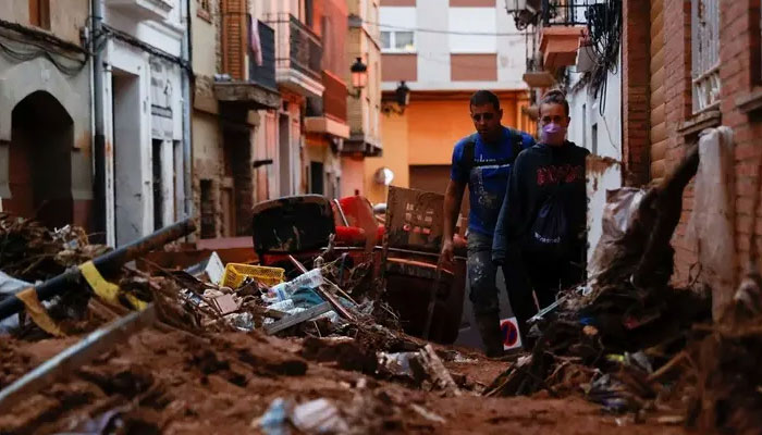 People walk through mud in a street, following heavy rains that caused floods, in Paiporta, near Valencia, Spain, on November 4, 2024. — Reuters