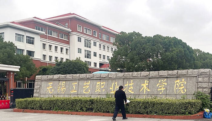 A man lays a bouquet of flowers at an entrance to the Wuxi Vocational College of Arts and Technology following a knife attack, in Wuxi, Jiangsu province, China November 17, 2024. — Reuters