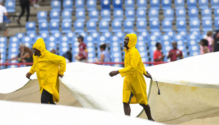 Ground staff cover the field during a rain delay of the 5th T20I cricket match between England and West Indies and at Daren Sammy Cricket Ground in Gros Islet, Saint Lucia, on November 17, 2024. — AFP