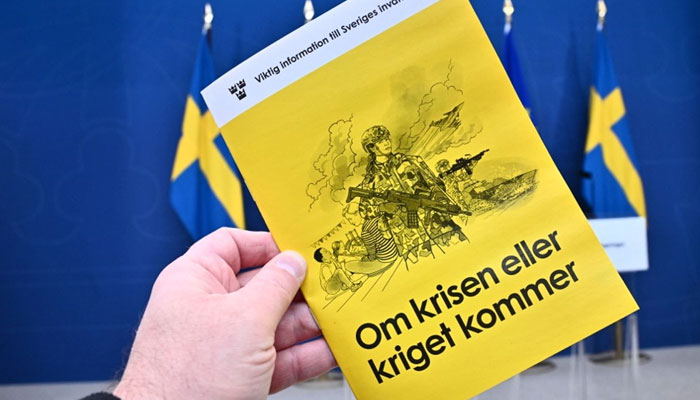 The new version of the preparedness booklet If the crisis or war comes, that will be distributed to all households, is seen during its presentation by Swedens Minister for Civil Defence in Stockholm, on October 8, 2024. — AFP