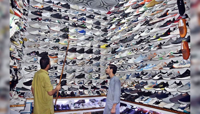 A vendor displaying shoes to attract customers in his shop on November 14, 2024. — APP