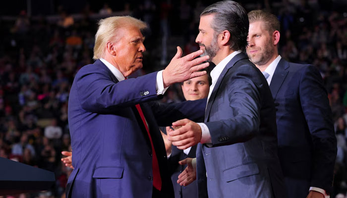 US President-elect Donald Trump approaches to embrace Donald Trump Jr at his campaign rally, at PPG Paints Arena in Pittsburgh, Pennsylvania, US on November 4, 2024. — Reuters