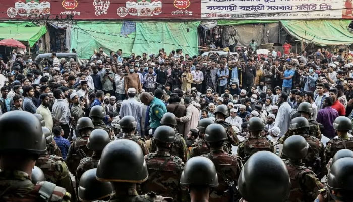 Bangladesh Army personnel stand guard as protesters stage a demonstration in front of the Bangla newspaper Prothom Alos office in Dhaka on Nov 25, 2024. — AFP
