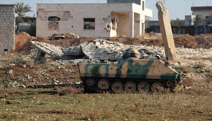 This picture shows a damaged Syrian Army armoured vehicle in front of a destroyed structure in the village of Miznaz which was taken over by the HTS and their Turkish-backed allies in the latest battles with government forces in the northern Syrian Aleppo province, on November 29, 2024. — AFP
