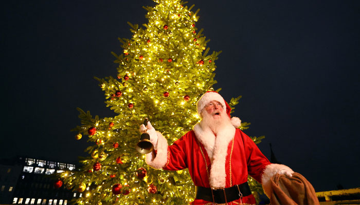 A man dressed as Santa Claus stands in front of an illuminated Christmas tree at the all-inclusive Christmas market at Spree river, in Berlin, Germany December 3, 2024. — Reuters