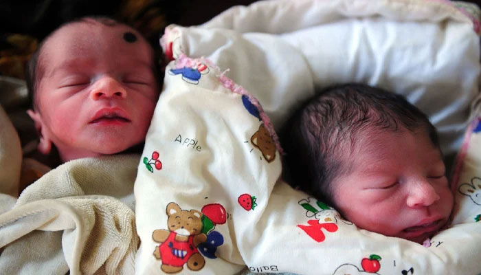A representational image of two newborn baby boys sleeping. — AFP/File