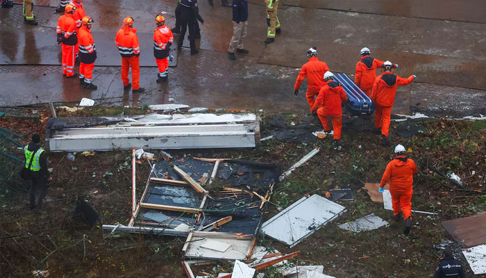 Firefighters carry a coffin as emergency personnel work at the scene of an explosion in a residential area in The Hague, Netherlands, December 7, 2024.— Reuters
