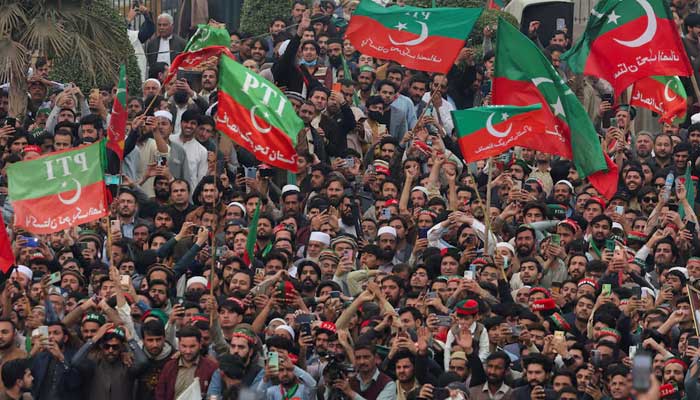 PTI supporters wave flags during a rally in Peshawar on February 17, 2024. — Reuters