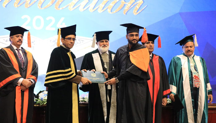 Federal Minister of Education Dr Khalid Maqbool Siddiqui (2nd left) awards a degree to graduate during the 11th convocation of the Quaid-i-Azam University (QAU) on December 123, 2024. — Facebook@QAUIslamabadofficial