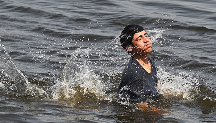 A boy cools off in the Arabian sea on a hot summer day in Karachi on May 23, 2024. — AFP