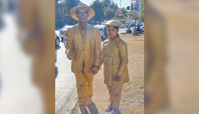 This image shows a gold boy and a girl standing on the road. — APP/File