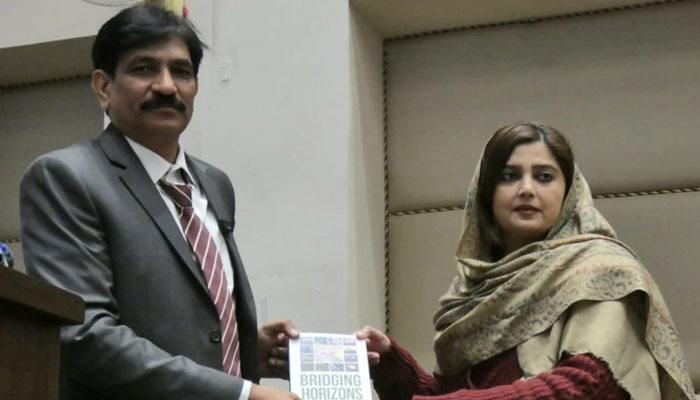 Dr Uzma Siraj giving away her book  in this image taken on December 14, 2024.—  Facebook@fuuast.ir