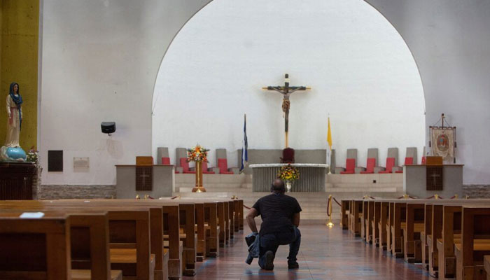 A man kneels down at a church. — Reuters/File