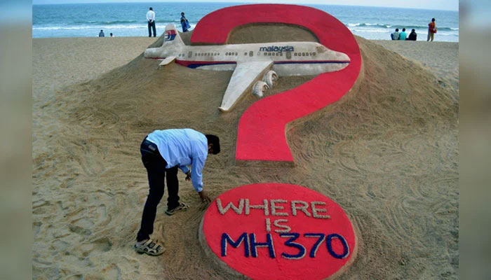 Indian sand artist Sudarsan Pattnaik creates a sand sculpture of the missing Malaysia Airlines flight MH370 on Puri beach in eastern Odisha, India on March 7, 2015. — AFP