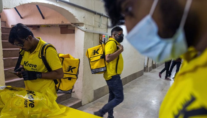 Krave Mart delivery riders check orders at one of the company’s locations in Karachi. — Krave Mart website/File