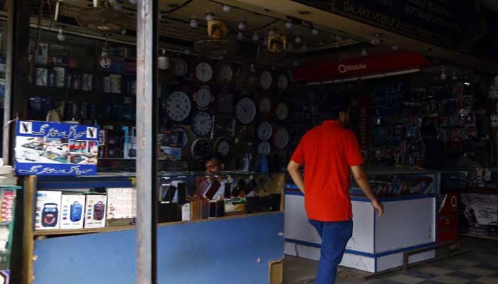 The representational image shows shopkeepers sitting at their shops amid prolonged power outage in Karachis Saddar area on Thursday, August 11, 2022. — PPI