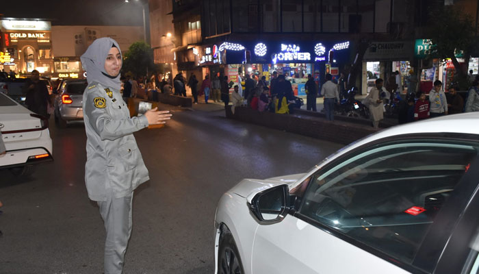 The image released on Nov 9, 2024 shows a lady officer of the Islamabad Traffic Police (ITP) regulating traffic in Islamabad. — Facebook/Islamabad Traffic Police