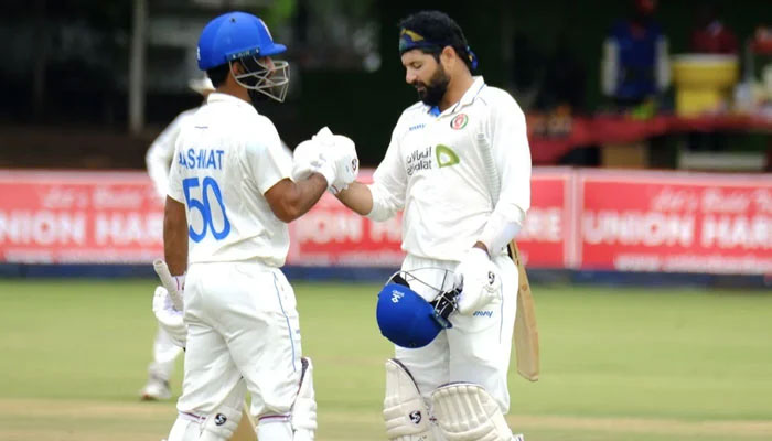 Afghanistans Hashmatullah Shahidi (left) and Asfar Zazai bump fists during fifth day of the first Test against Zimbabwe on December 30, 2024. — Zimbabwe Cricket