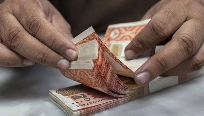 A person counting Pakistani currency notes.—AFP/File