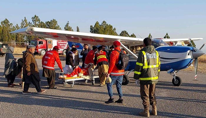 Volunteers of Edhi carry an injured person to board a plane in Parachinar, on December 17, 2024. — AFP