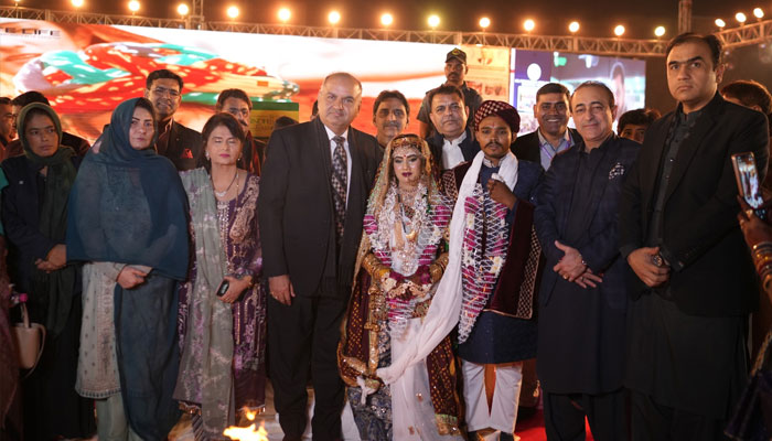 PHC Patron-in-chief Dr Ramesh Kumar Vankwani seen with a birde and groom at the Pakistan Hindu Councils (PHC) mass wedding ceremony held at the Railway Ground on II Chundrigar Road on January 12, 2025.— Facebook@pakistanhinducouncil