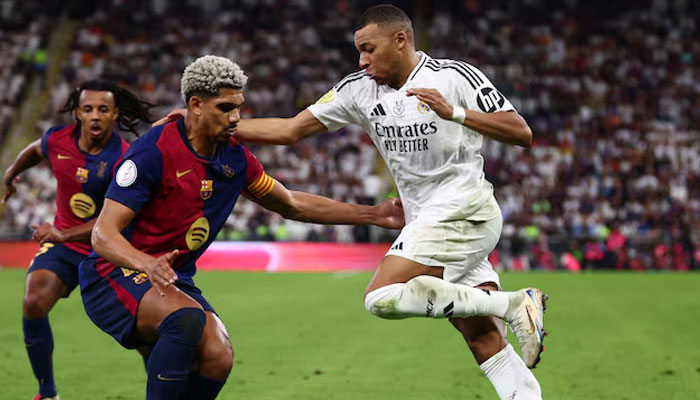 Real Madrids Kylian Mbappe in action with FC Barcelonas Ronald Araujo on  January 12, 2025. — Reuters
