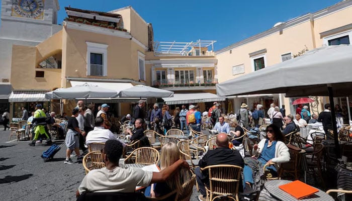 People sit at the tables outside restaurants and cafes on Capri Island, Italy, April 18, 2024.— Reuters