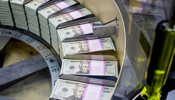 Packs of freshly printed 20 USD notes are processed for bundling and packaging at the US Treasurys Bureau of Engraving and Printing in Washington. — AFP/File
