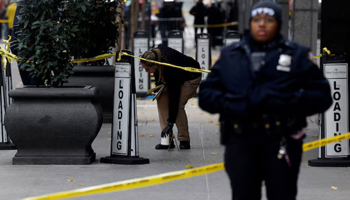 A member of the NYPD Crime Scene Unit works near evidence markers placed where shell casings were found at the scene where the CEO of UnitedHealthcare Brian Thompson was reportedly shot and killed in Midtown Manhattan, in New York City, US, December 4, 2024. — Reuters