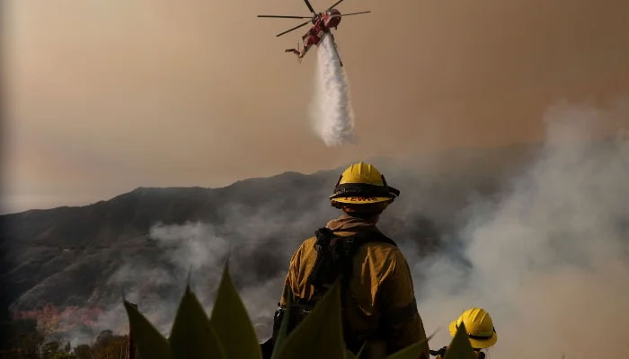 A firefighting helicopter drops water on the Palisades Fire on January 10, 2025 in Los Angeles, California, US. — AFP