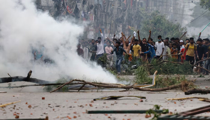 People gesture near smoke as protesters clash with Border Guard Bangladesh (BGB) and the police July 19, 2024. — Reuters