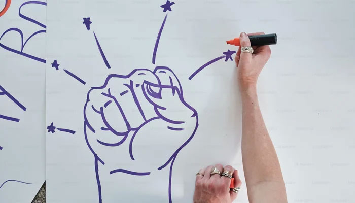 A representational image shows a fist drawn on a piece of paper. — Unsplash/File