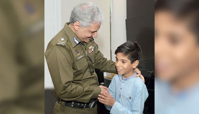 Inspector General of Police Punjab Dr Usman Anwar shakes hands with a child at the Central Police Office on July 25, 2024. — Facebook@PunjabPolicePakistan