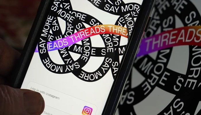 The image shows the login page of the Meta platform Threads at a mobile phone held by a user. — The Canadian Press/File