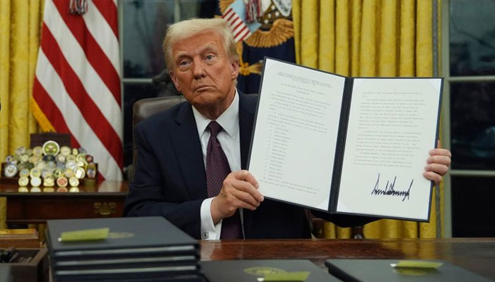 Donald Trump with a singed copy of his executive orders. — PTI/File