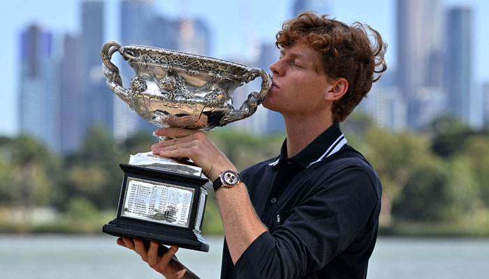 Italys Jannik Sinner poses with the Norman Brookes Challenge Cup trophy following his victory against Germanys Alexander Zverev in the mens singles final match of the Australian Open tennis tournament in Melbourne on January 27, 2025. — AFP
