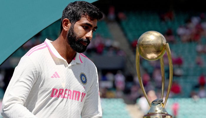Indias Jasprit Bumrah reacts as he walks past the trophy during an official ceremony after the fifth cricket Test match between Australia and India at The SCG in Sydney on January 5, 2025. — AFP