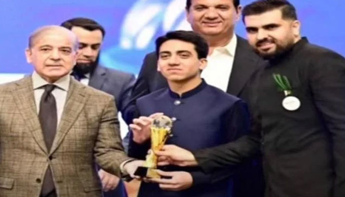 Prime Minister Shehbaz Sharif conferring an award on Ali Saif (centre), the youngest member of the Youth Council and the head of the “Milkar” organisation. — Screengrab via YouTube/Geo News/File